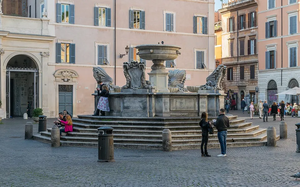 A stone fountain and the surrounding square in Trastevere, Rome