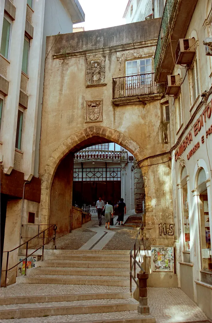Stone arches and a passageway inside a building in Coimbra.