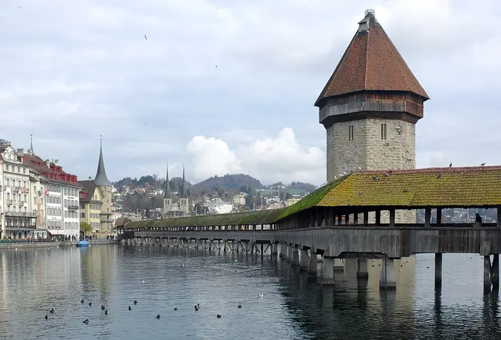 Covered wooden bridge and stone tower over the river in Lucerne.