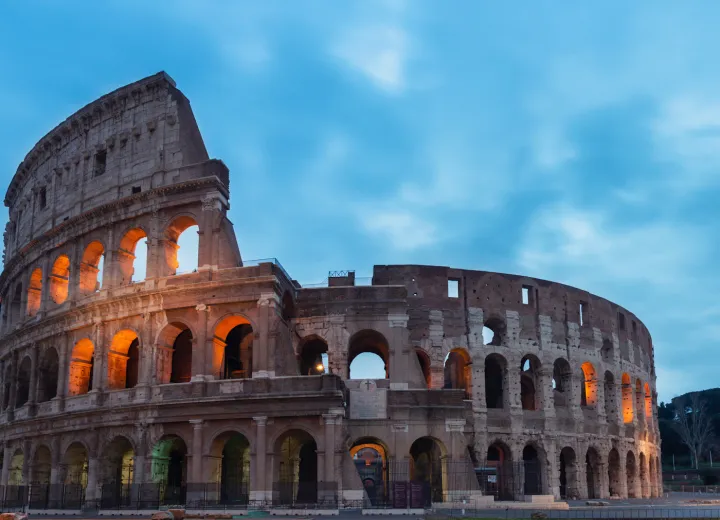 The illuminated arches of the Colosseum in Rome at dusk